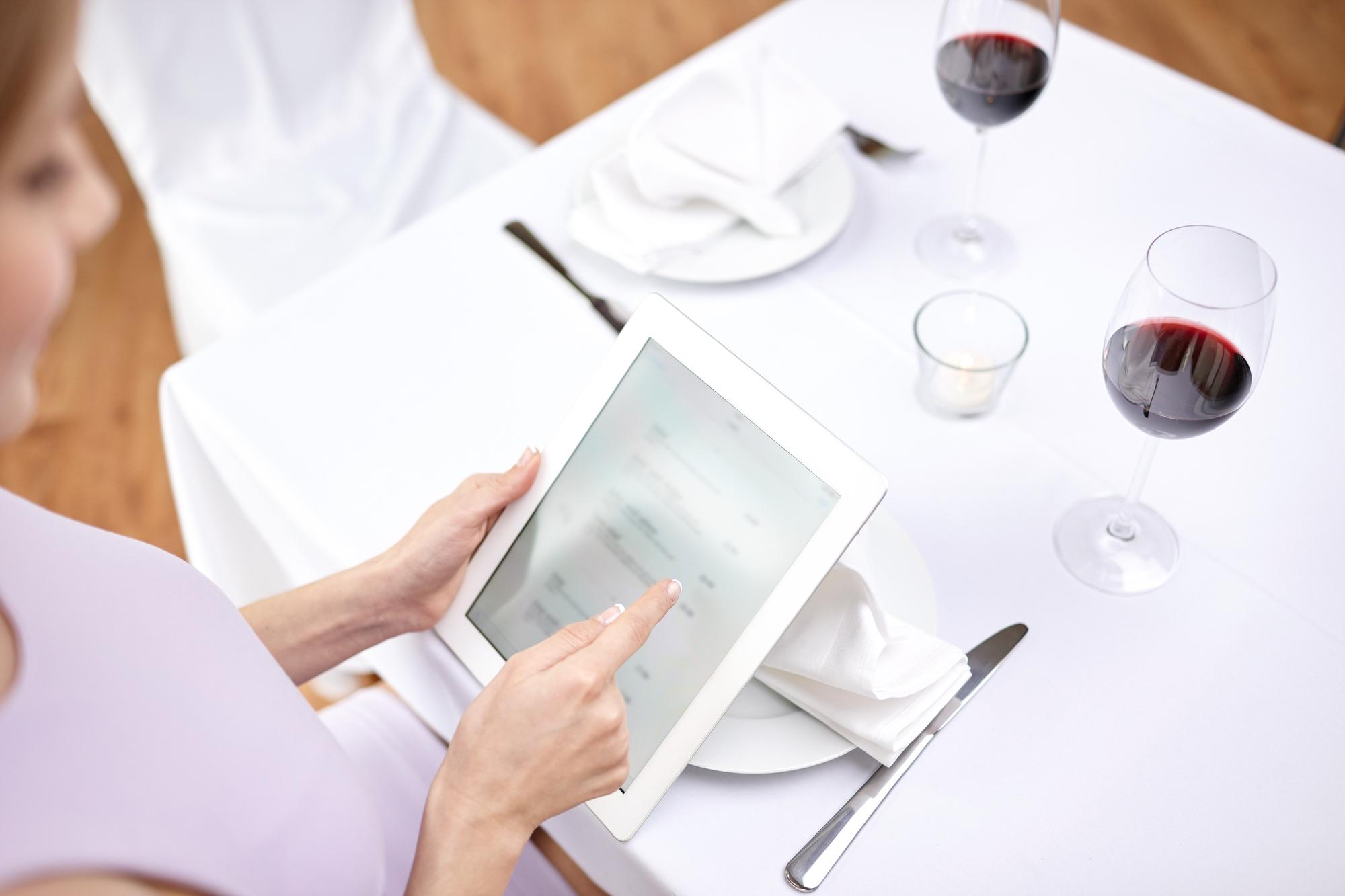Table set for tasting menu with tech devices nearby